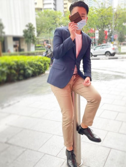 a guy holding onto a slim leather wallet